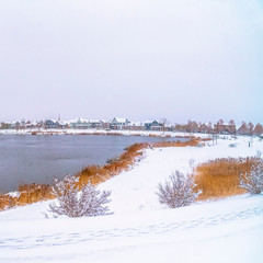 Frame Square Panorama of a silvery lake with snow covered shore and metal bridge