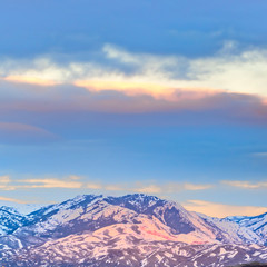Square Panorama of a magnificent snow covered mountain beyond a lake at sunset