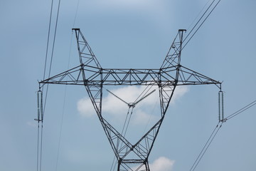 Power line support. Electric wires on a blue sky background. High-voltage lines in the modern city.