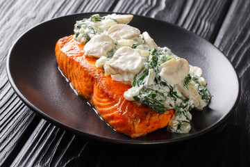  Italian salmon fillet recipe consists of topped with creamy spinach and mushrooms on a plate on the table. horizontal