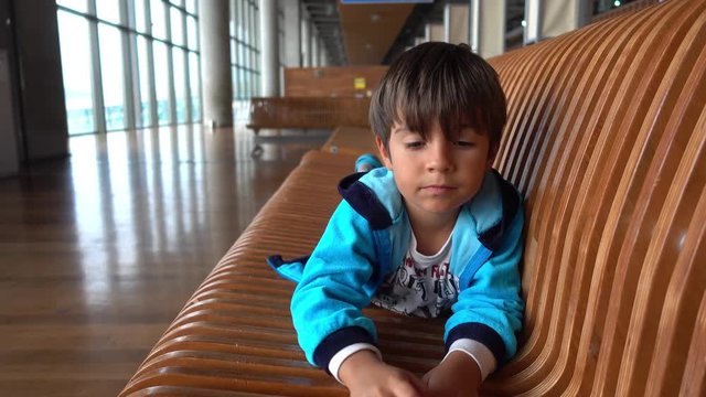 Dalaman Airport, Turkey - 24th of May 2018: 4K Sleepy child on bench in the airport