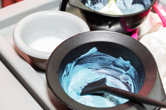 Hair dye in bowls and brush for hair coloring.