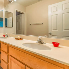 Frame Square Vanity with double sink and wood cabinets inside the small bathroom of a home