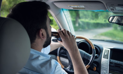 man drinking alcohol while driving a car