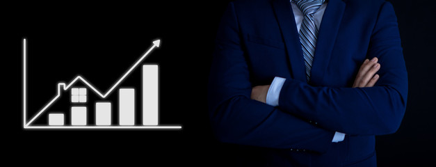 businessman with a growing schedule of real estate on a black background