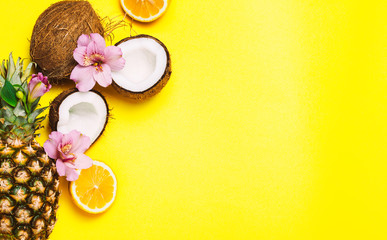 Tropical fruits and flowers on yellow background.