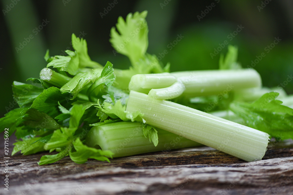 Wall mural fresh celery vegetable / bunch of celery stalk with leaves on wood and nature green - Wall murals