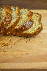 Sliced Brioche toast loaf with bread crumbs on wood cutting board