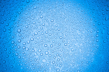 Rain droplets on blue glass background, Water drops on glass.