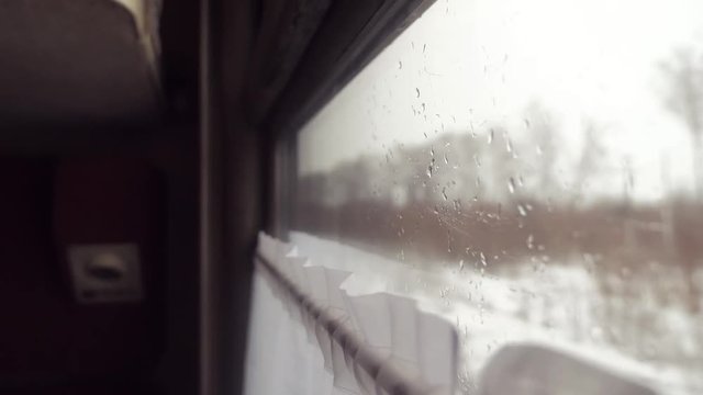 rain snow on glass window. railway concept train journey travel. view beautiful from the window of a moving train railway trip Russia winter. slow motion video. interior lifestyle inside train