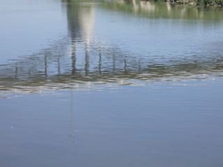 Reflejos en el agua de un río, reflejo de un puente moderno