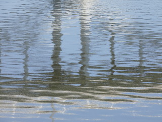 Reflejos en el agua de un río, reflejo de un puente moderno