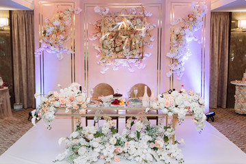 Table of newlyweds decorated with flowers, foods and fabrics. Concept of wedding