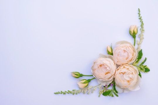Floral arrangement, web banner with pink English roses, ranunculus, carnation flowers and green leaves on white table background. Flat lay, top view. Wedding or birthday styled stock photography.