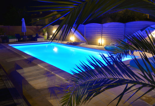 water of swimming pool illuminated in blue by night