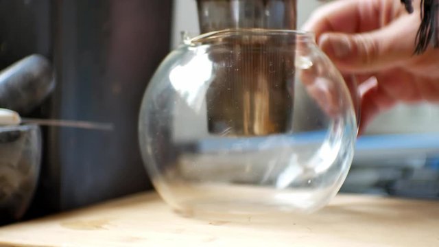 Stainless coffee filter placed into glass jug preparing to make fresh ground morning coffee.