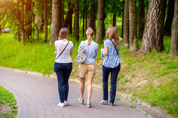 Obraz premium Three girls walk in the summer Park