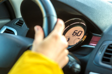 Modern car interior with driver hand on steering wheel. Safe driving concept.