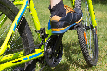 foot on the bike pedal,Close up of the leg stand on the bike pedal on the grass