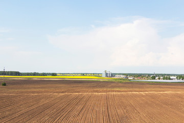 Field of rapeseed flowers, plant for cleaning and storage of agricultural products, flour, cereals and grains.
