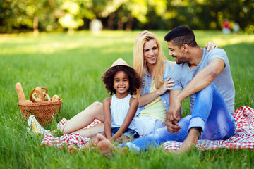 Fototapeta premium Picture of lovely couple with their daughter having picnic