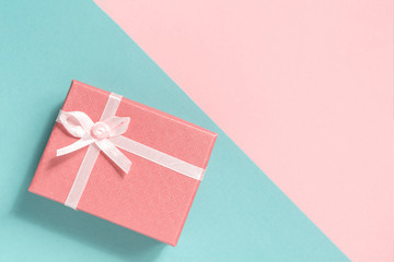 Pink pastel gift box on a blue background. Two-color background.