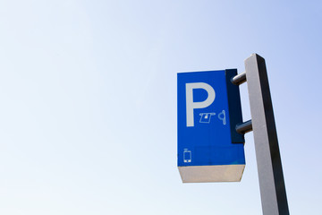 Paid parking ticket sign / pole shot against a blue sky.