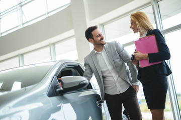 Portrait of happy customer buying new car