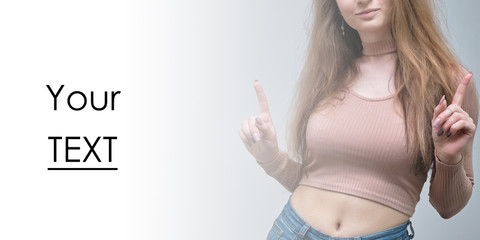 A portrait of a beautiful girl woman on a white background with long beautiful hair in a pink sweater and blue jeans is standing right in front of the camera and smiling.