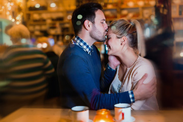 Happy couple kissing at bar and having date