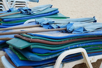 low season on the beach with stacked beach chairs