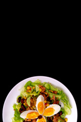 Tuna salad with lettuce, eggs and tomatoes with breads on black table. Diet menu. Top view. Restaurant salad menu concept. Food bloggers background.