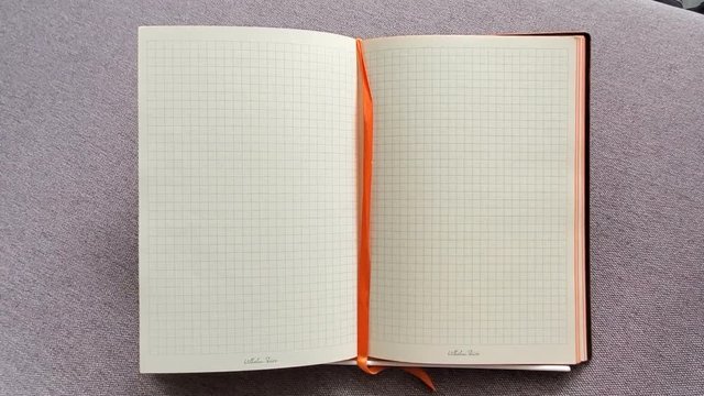 Open the notebook in a cage on table. Open diary in the box. Close-up video motion. Business concept, place for text. Copy space for your text