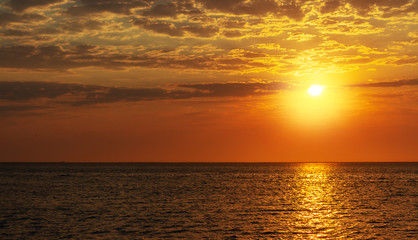 beautiful red sunset, dark clouds and ocean on the horizon