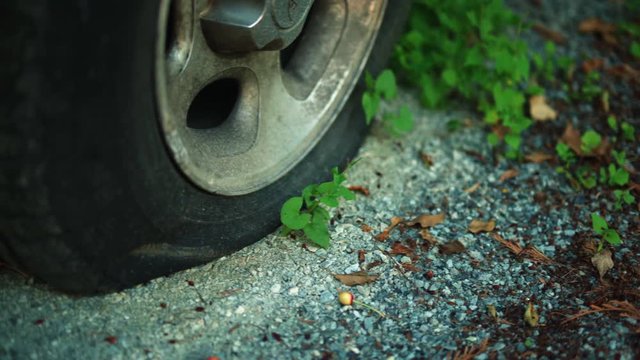 Pan Over To Flat Tire Resting On A Gravel Road