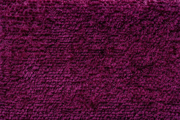 Dark purple fluffy background of soft, fleecy cloth. Texture of textile closeup