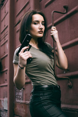 Fototapeta na wymiar Powerful Woman Holding Gun Action Movie Style. Train adventure. Military girl with .