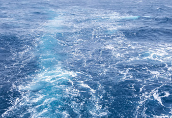 Boat Wave ocean trace on blue sea fresh water background.