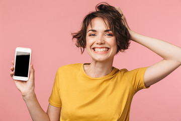 Fototapeta premium Happy young beautiful woman posing isolated over pink wall background using mobile phone.