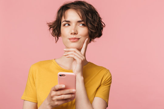 Thinking Dreaming Young Beautiful Woman Posing Isolated Over Pink Wall Background Using Mobile Phone.