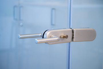 Modern, contemporary glass door lock handle in modern business office.