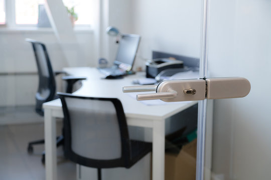 Modern, Contemporary Glass Door Lock Handle With Modern Business Office In The Background.