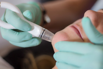Close-up view of female face having facial treatment at the beauty salon.