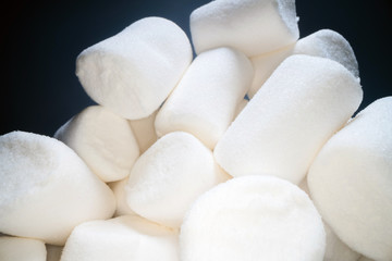 Pile of sweet and soft marshmallow. Yummy white sweets on dark background, fast food