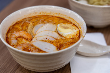 Fototapeta na wymiar Laksa is a spicy noodle soup popular in Peranakan cuisine of Southeast Asia