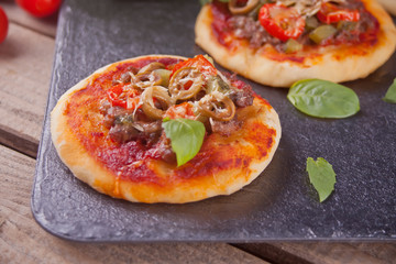 Homemade mini pizza on the black background.