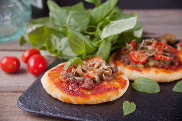 Homemade mini pizza on the black plate.