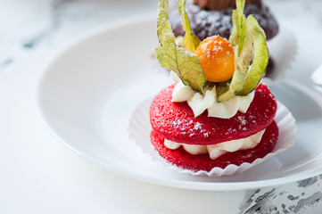 One red whoopie pie on a white plate.