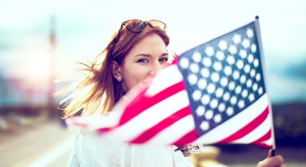 Young patriot modern woman holding USA flag depth of field - Powered by Adobe