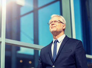 business and people concept - senior businessman on city street